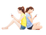 two happy pretty woman playing smart phone
