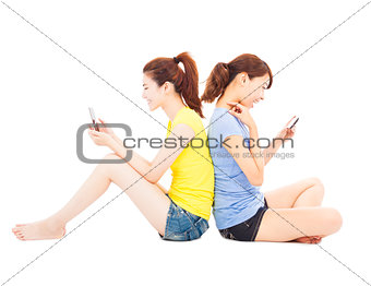 two happy pretty woman playing smart phone