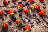 Blueberry and strawberries on wood in nature