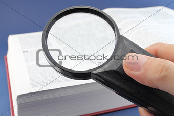 Reading a book with magnifying glass