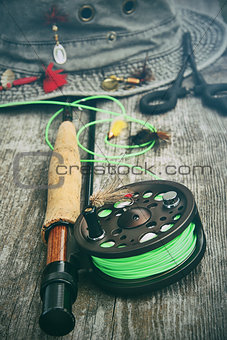 Fly fishing reel with old hat on bench 