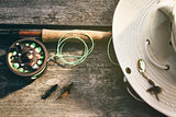 Fly fishing rod with hat on wood