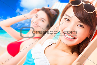  young girls sunbathing and lying on a beach chair
