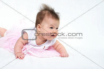 Newborn baby in pink dress s looking away