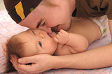 Daddy playing with newborn baby