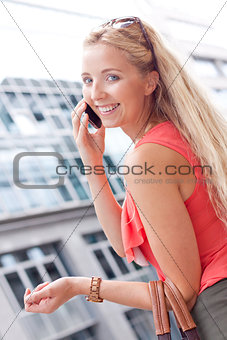 attractive young blonde woman talking on the phone outdoor
