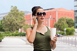 attractive young woman with smartphone and sunglasses outdoor