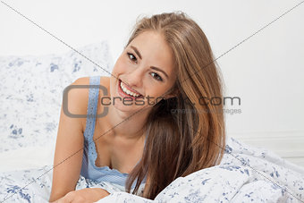 young brunette woman lying in bed sleeping morning 
