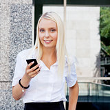 smiling attractive blonde businesswoman with smartphone 