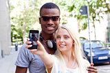 young smiling multiracial couple taking foto by smartphone 