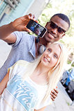 young smiling multiracial couple taking foto by smartphone 