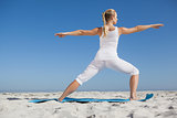 Calm woman standing in warrior pose on beach
