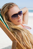 Gorgeous blonde in sunglasses sitting at the beach