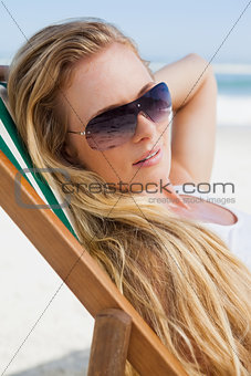 Gorgeous blonde in sunglasses sitting at the beach