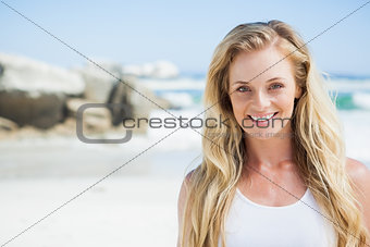 Gorgeous blonde smiling at camera on the beach