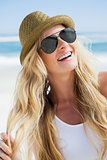 Stylish blonde smiling on the beach