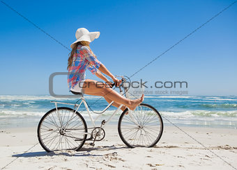 Pretty carefree blonde on a bike ride at the beach
