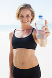 Fit blonde drinking water on the beach