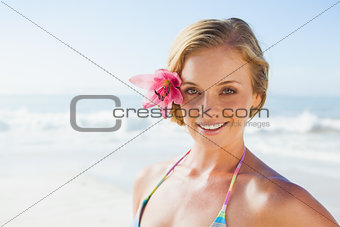 Gorgeous blonde in bikini smiling at camera on the beach