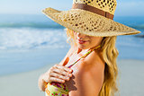 Gorgeous blonde in bikini applying suncream on the beach