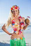 Gorgeous blonde in garland holding coconut drink on the beach