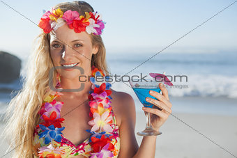 Gorgeous blonde in garland holding cocktail on the beach