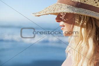 Gorgeous blonde in straw hat smiling on beach