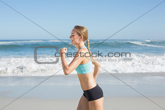 Fit blonde jogging on the beach
