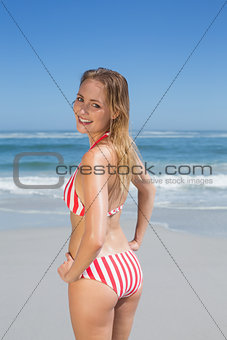 Smiling fit woman in striped bikini at beach
