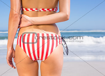 Mid section rear view of fit woman in bikini on the beach
