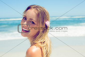 Beautiful blonde smiling at camera on the beach