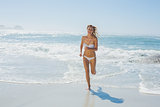 Gorgeous blonde in white bikini running from the sea