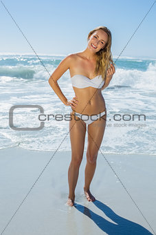 Gorgeous blonde in white bikini standing in the sea