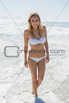 Gorgeous blonde in white bikini standing in the sea