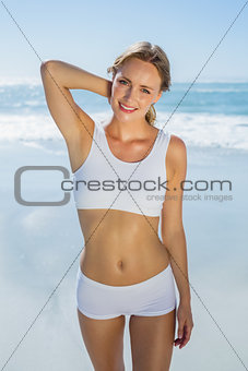 Gorgeous blonde standing by the sea smiling at camera