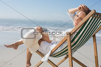 Woman relaxing in deck chair by the sea