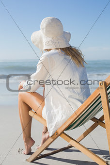 Blonde relaxing in deck chair by the sea