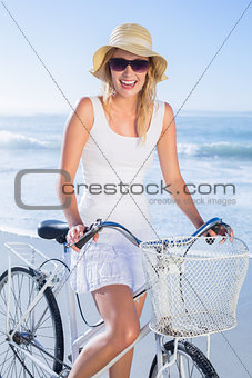 Gorgeous happy blonde on a bike ride at the beach
