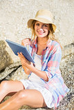Gorgeous happy blonde using tablet pc at the beach