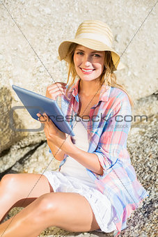 Gorgeous happy blonde using tablet pc at the beach