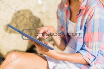 Woman using tablet pc at the beach