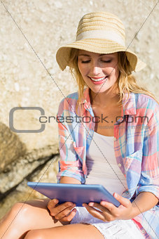 Pretty blonde using tablet pc at the beach