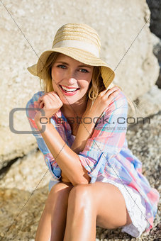 Pretty blonde smiling at camera at the beach