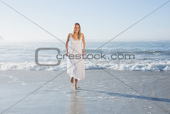 Pretty blonde at the beach in white sundress