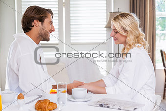 Cute couple having breakfast in their bathrobes