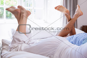 Couples legs lying on bed