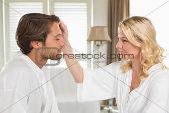 Cute couple in bathrobes spending time together