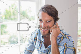 Smiling casual man talking on smartphone