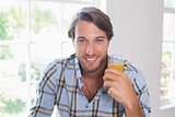 Casual smiling man having orange juice
