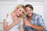 Cute young couple sitting on floor together having white wine